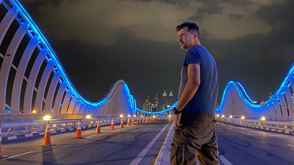 Ruslan Selivanov standing on an illuminated bridge at night